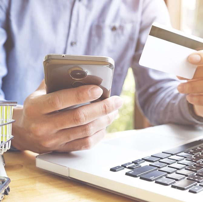 Man using laptop and mobile phone to online shopping and pay by credit card. Vintage tone, Retro filter effect, Soft focus, Low light.(selective focus)